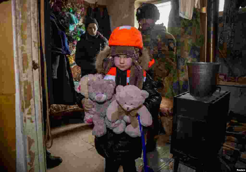6-летняя Арина в бронежилете и каске, с игрушками в руках, готовится к эвакуации из Бахмута. 31 января 2023. &nbsp;