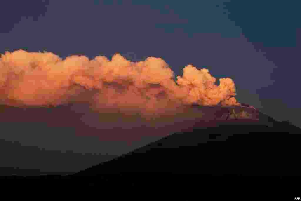 Abu vulkanik dan asap mengepul dari gunung berapi Popocatepetl seperti yang terlihat dari komunitas Santiago Xalitzintla, negara bagian Puebla, Meksiko, Kamis (25/5). (AFP)&nbsp;