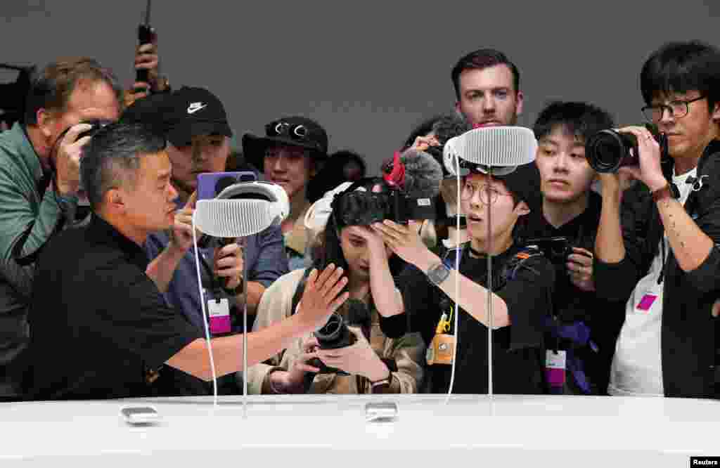 People take pictures of Apple's Vision Pro headsets at Apple's annual Worldwide Developers Conference at the company's headquarters in Cupertino, California, June 5, 2023. 