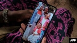 FILE: Bethy Kahindi, 37, shows a picture on her phone of three of six daughters of her 45-year-old sister as she looks for their bodies at the morgue of Malindi Sub-County Hospital in Malindi, on April 26, 2023. On June 21, 2023, suspect Joseph Buyuka died from his hunger strike.