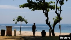 FILE - A tourist enjoys a beach in Nusa Dua, Bali, Indonesia, Nov. 17, 2022. Many East and Southeast Asian nations have launched digital nomad visas that allow remote workers to live and work there. 