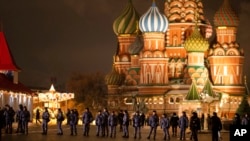 Police and the Rosguardia (National Guard) servicemen walk in Red Square, closed for celebrations on New Year's Eve, with the St. Basil's Cathedral, in Moscow, Dec. 31, 2022. 