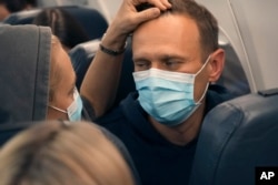 FILE - Alexei Navalny and his wife, Yulia, sit on the plane on a flight to Moscow from Berlin on Jan. 17, 2021. Navalny flew home to Russia after recovering in Germany from his poisoning in August 2020 with a nerve agent.
