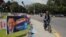 A person rides a bicycle next to posters of candidates for the general elections, in Guatemala City, Guatemala, March 27, 2023.
