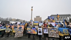 FILE - Relatives of Ukrainian prisoners said to have been captured by Russian forces hold posters showing their portraits during a at Independence Square in Kyiv on Jan. 14, 2023, as they call to hasten their release from alleged Russian captivity.