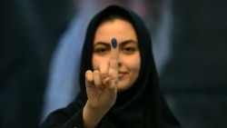 Seorang perempuan Iran memperlihatkan jarinya yang sudah ditandai tinta usai mencoblos untuk memilih presiden baru, di Kedubes Iran di Kuwait, Jumat, 28 Juni 2024. (Foto: Yasser Al-Zayyat/AFP)