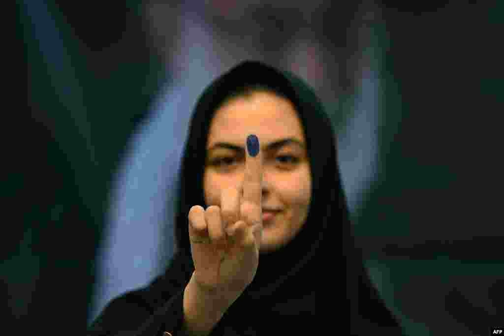 An Iranian national shows her ink-marked finger after voting in the presidential election at the Iranian Embassy in Kuwait City. (Photo by YASSER AL-ZAYYAT / AFP)