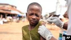 FILE - A health worker administers a cervical cancer vaccine HPV Gardasil to a girl on the street in Ibadan, Nigeria, on May 27, 2024.