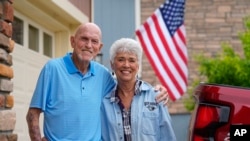 Tom McAdam and his wife, Beverly, stand outside their home, May 31, 2024, in Broomfield, Colo. The retired couple's home in the northwest Denver suburb has risen 45% in value since they purchased it six years ago.