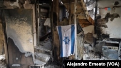 Una bandera de Israel y una planta eléctrica en el interior de una vivienda arrasada por Hamás en el kibutz Be'eri.