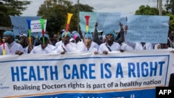FILE - Kenyan doctors chant outside the health ministry headquarters protesting with placards to demand better pay and working conditions in the capital, Nairobi, Kenya, April 9, 2024.