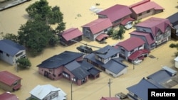 An aerial view shows a Japan Self-Defense Forces helicopter conducting a search and rescue operation over a flooded residential area in Tozawa Town, Yamagata Prefecture, Japan, July 26, 2024, in this photo taken by Kyodo.