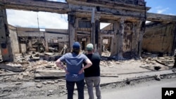 Hawaii Gov. Josh Green, right, and FEMA Administrator Deanne Criswell look at a destroyed building along Front Street during a tour of wildfire damage on Aug. 12, 2023, in Lahaina, Hawaii.
