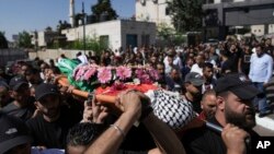 Mourners carry the body of Qusai Matan, 19, during his funeral in the West Bank city of Ramallah, Aug. 5, 2023. 