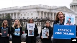 FILE - Women hold photos of their loved ones during a rally to protect kids online on Capitol Hill in Washington, Jan. 31, 2024. The U.S. Senate passed major online child safety reforms on July 30, 2024. The bills' future in the House of Representatives is uncertain.