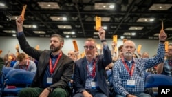 Messengers raise their ballots in support of a motion put up for vote during a Southern Baptist Convention annual meeting, June 11, 2024, in Indianapolis.