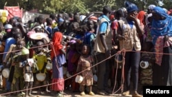 FILE - Cameroonians who fled deadly intercommunal violence between Arab Choa herders and Mousgoum and Massa farming communities queue to receive food at a temporarily refugee camp on the outskirts of Ndjamena, Chad, Dec. 13, 2021.
