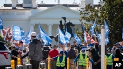 FILE - People protest for an extension and expansion of the Temporary Protected Status (TPS) program, Friday, Sept. 23, 2022, at Lafayette Park by the White House in Washington.