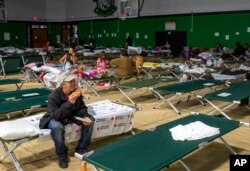 Steven Dobrovolskis eats a slice of pizza while spending the night at a shelter in Roswell, New Mexico, after evacuating from Ruidoso, June 18, 2024.