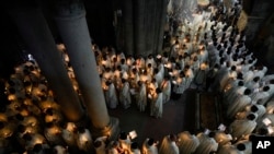 Catholic clergy hold candles as they walk during the Washing of the Feet procession at the Church of the Holy Sepulcher, where many Christians believe Jesus was crucified, buried, and rose from the dead, in the Old City of Jerusalem.