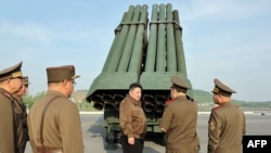 Pemimpin Korea Utara Kim Jong Un memeriksa sistem peluncur roket ganda 240 mm di lokasi yang dirahasiakan, 10 Mei 2024. (Foto: via AFP)