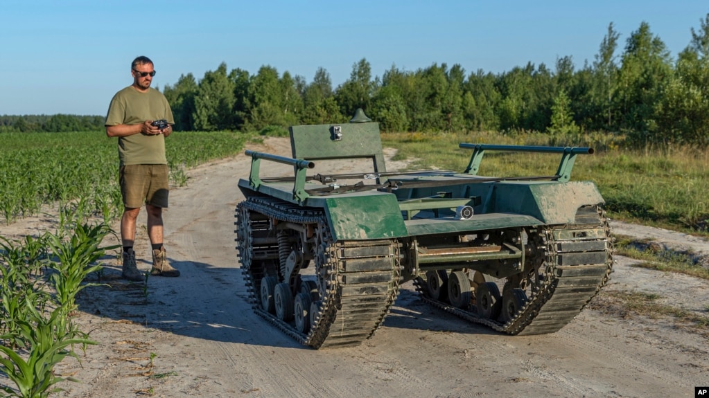 Andrii Denysenko, CEO of design and production bureau "UkrPrototyp", stands by Odyssey, an 800-kilogram (1,750-pound) ground drone prototype, at a corn field in northern Ukraine, Friday, June 28, 2024. (AP Photo/Anton Shtuka)