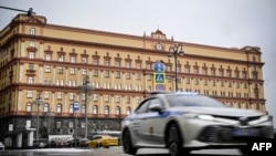 FILE - A police car goes past the headquarters of the Federal Security Service in central Moscow on March 3, 2023. Two Ukrainian journalists were detained by the Russian Federal Security Service in August 2023. Their whereabouts are unknown.
