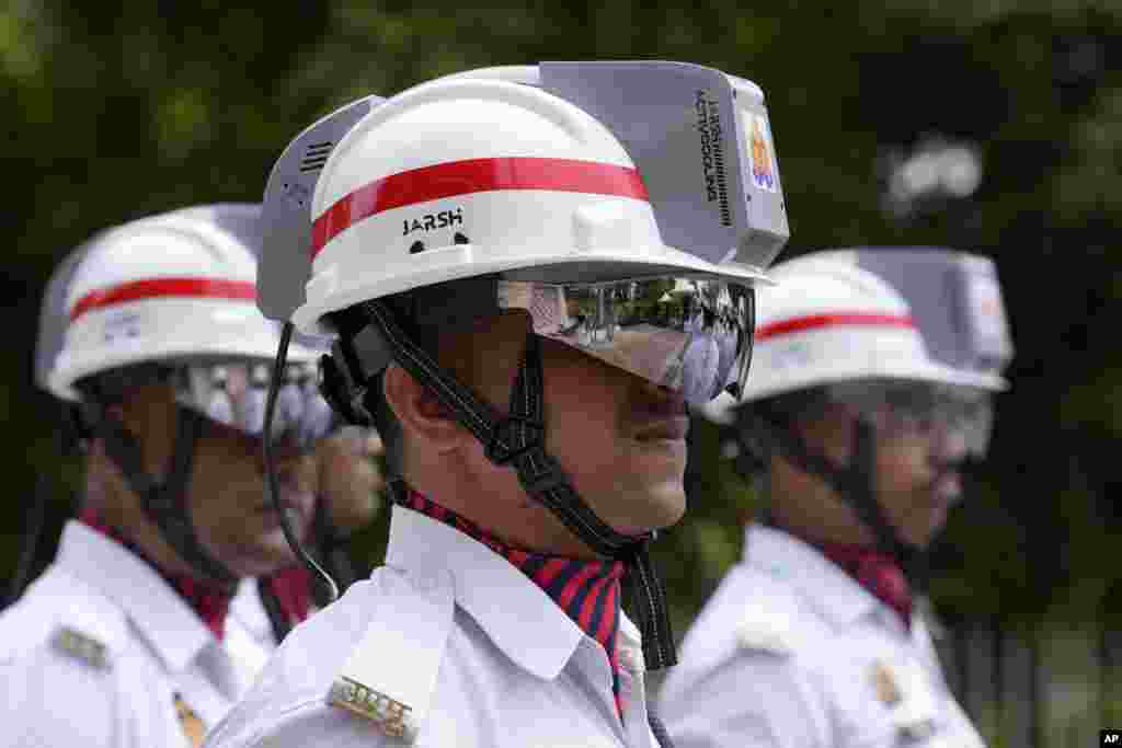 Traffic police personnel wear special-issued helmets with inbuilt air-conditioning units in Lucknow, India.