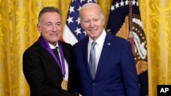 Presiden AS Joe Biden bersanding dengan penyanyi Bruce Springsteen setelah memberikan penghargaan Medali Seni Nasional kepada sang penyanyi di Gedung Putih, Washington, pada 21 Maret 2023. (Foto: AP/Susan Walsh)