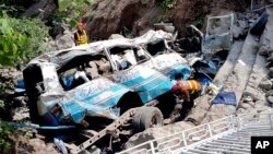 Rescue workers look for the victims and wounded passengers from the wreckage of a bus that fell into a ravine, near Kahuta, Pakistan, Aug. 25, 2024. 