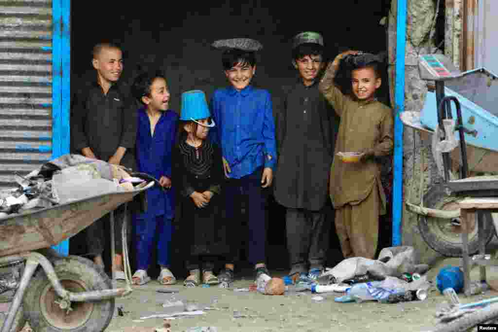 Afghan children stand at a scrap shop outside a World Food Program (WFP) distribution center in Kabul.