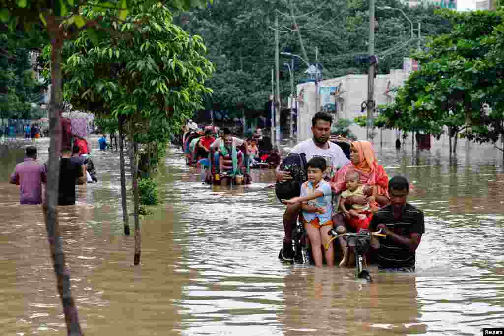 People move on rickshaws along a flooded street after a downpour in Dhaka, Bangladesh.