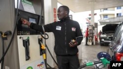 Un homme fait le plein d'essence dans une voiture dans une station-service à Nairobi, le 17 mai 2023.