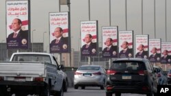 Vehicles pass near banners supporting Egyptian President Abdel-Fattah el-Sissi for the presidential elections, in Cairo, Egypt, Dec. 10, 2023.