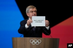 IOC president Thomas Bach holds the board Salt Lake City during the 142nd IOC session at the 2024 Summer Olympics, July 24, 2024, in Paris, France.