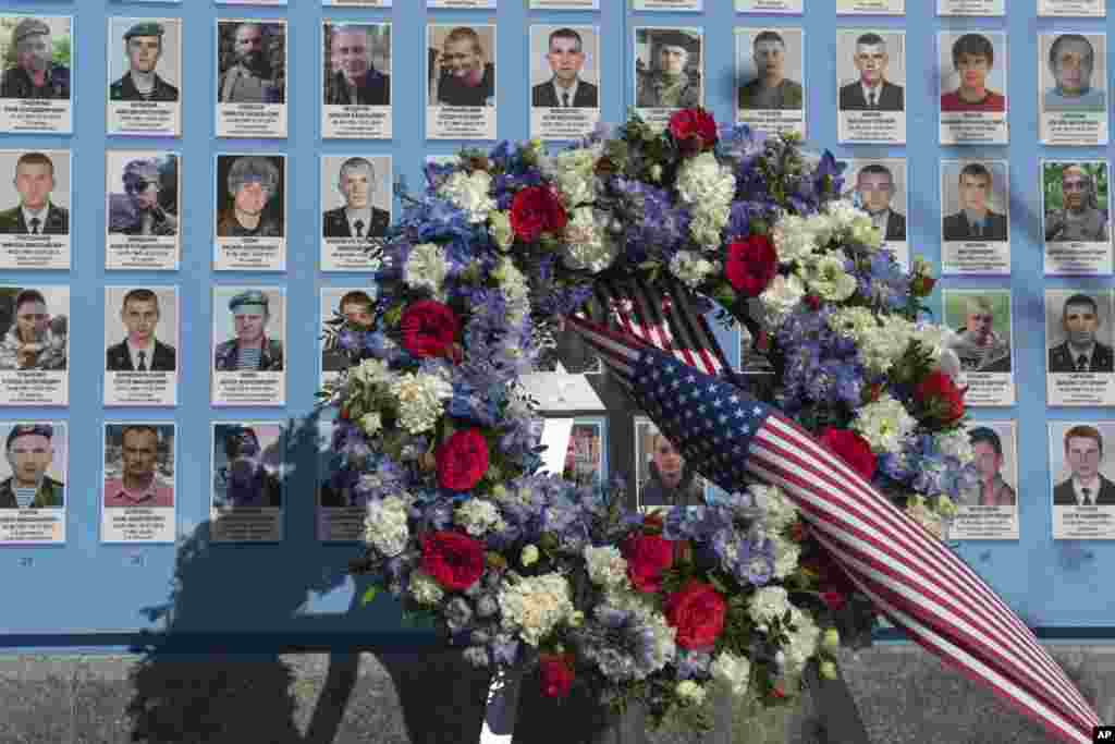 Flowers placed by the President Joe Biden at the Memorial Wall of Fallen Defenders of Ukraine in Russian-Ukrainian War with photos of killed soldiers in Kyiv, Feb. 20, 2023.&nbsp;
