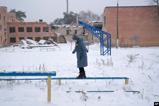 FILE - A child plays near School No. 21, which was destroyed by the Russian army, in Chernihiv, Ukraine, on Jan. 16, 2023. (AP Images for Global Partnership for Education)