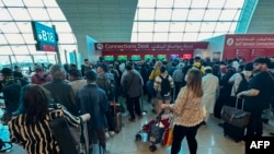 FILE - Passengers queue at a flight connection desk at the Dubai International Airport in Dubai, United Arab Emirates, April 17, 2024. 