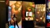 FILE - A visitor observes a display of late hip-hop artist Tupac Shakur during the press preview day for the 'Tupac Shakur. Wake Me When I'm Free' exhibition, Jan. 20, 2022, at The Canvas at L.A. Live in Los Angeles. 