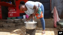 FILE - Mercy Letting, 33, prepares a meal outside her restaurant in Nairobi, Kenya, May 21, 2024.