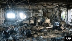A fire-damaged vehicle is seen inside the Sodauto car dealership in Magenta, suburbs Vallee des Colons, in France's Pacific territory of New Caledonia in Noumea, more than two weeks after deadly riots broke out in the Pacific territory. 