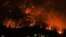 The McDougall Creek wildfire burns on the mountainside above houses in West Kelowna, British Columbia, Canada, Aug. 18, 2023. 
