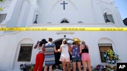 ARCHIVO - Un grupo de mujeres oran juntas en un memorial improvisado en la acera frente a la Iglesia Emanuel AME el 18 de junio de 2015 en Charleston, Carolina del Sur, EEUU.