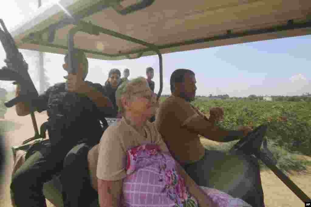 Palestinians transport a captured Israeli civilian, center, from Kibbutz Kfar Azza into the Gaza Strip on Oct. 7, 2023.