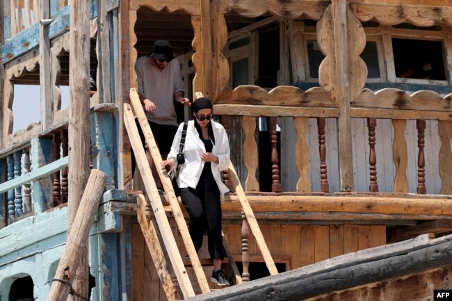 Tourists visit a traditional wooden ships, called lenjes, on Iran's touristic Qeshm island in the Gulf, on April 29, 2023.