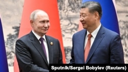 រូបឯកសារ៖ ប្រធានាធិបតីរុស្ស៊ី លោក Vladimir Putin ចាប់ដៃជាមួយប្រធានាធិបតីចិន លោក Xi Jinping អំឡុងពេលកិច្ចប្រជុំនៅទីក្រុងប៉េកាំង ប្រទេសចិន ថ្ងៃទី១៦ ខែឧសភា ឆ្នាំ ២០២៤។
