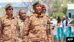 FILE - Sudan's army chief Abdel Fattah al-Burhan visits casualties receiving treatment at a hospital in the southeastern Gedaref state, April 10, 2024. De facto leader received an Iranian ambassador, July 21, 2024 and sent his own to Tehran, the government said.