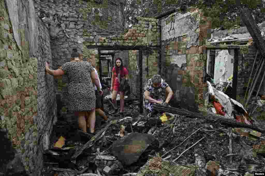 Local residents collect belongings in their destroyed building hit by a Russian missile strike in Zaporizhzhia, Ukraine.