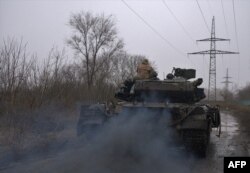 A Ukrainian T-64 tank rolls along a muddy lane from the town of Chasiv Yar, Donetsk region to Bakhmut on March 9, 2023.