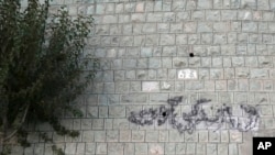 FILE - Graffiti on a wall in Tehran, Iran, on Sept. 11, 2023, reads in Farsi: "Woman, Life, Freedom," the key slogan of anti-government protests after the death of Mahsa Amini.